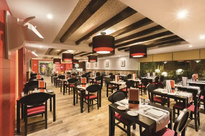 Hotel Riu Bravo igen igényes a konyhájára. Ajánlom a lokális gasztro élmények kiaknázását. Kóstold meg a helyi dolgokat. Paella Mallorquina – A klasszikus spanyol rizses étel helyi változata, amely gyakran tartalmaz tengeri herkentyűket, csirkehúst és zöldségeket. Tumbet – Egy tradicionális mallorcai rakott zöldséges fogás padlizsánnal, burgonyával, paprikával és paradicsomszósszal, gyakran grillezett hallal vagy hússal tálalva. Sobrasada – Mallorcai fűszeres kolbászkrém, amit pirítósra kenve vagy meleg ételekhez adva kínálnak. Frito Mallorquín – Serpenyőben sült belsőségek és zöldségek keveréke, erőteljes fűszerezéssel – igazi helyi különlegesség. Ensaimada – Bár nem főétel, ez a spirál alakú, porcukorral hintett édes péksütemény szinte kötelező desszert Mallorcán.