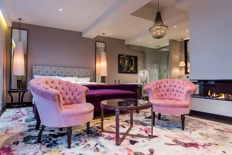 A Hotel Zoo Berlin szobái és lakosztályai a boutique hotel élmény esszenciáját hozzák: karakteres, művészi és mélyen személyes terek, ahol minden részletnek szerepe van. A meleg fények, a gazdag textúrák, a vibráló színek és a modern luxust idéző elemek együtt olyan atmoszférát teremtenek, amely egyszerre elegáns és otthonos.A gondosan megkomponált enteriőr — a kényelmes ülősarkok, a puha anyagok, a hangulatos kandalló és a látványos design‑megoldások — azt sugallja, hogy itt a vendég nem csupán megszáll, hanem élményt kap. A Hotel Zoo Berlin szobái tökéletesen ötvözik a kreatív vizualitást a kényelemmel, így akár egy rövid városnézésre, akár egy hosszabb berlini tartózkodásra érkezel, a tér minden pillanatban inspiráló marad.