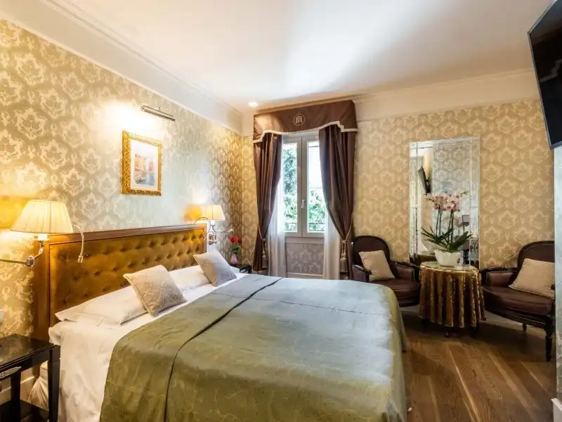 Hotel Moresco elegáns szoba zöld ágytakaróval, tükrös sarokkal és orchideával