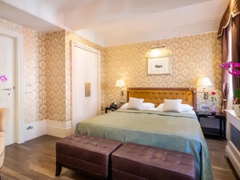 Hotel Moresco klasszikus szoba zöld ággyal és két bársonyos paddal Velencében