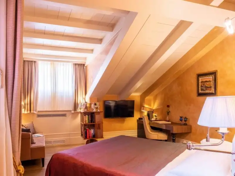 Tetőtéri szoba a Hotel Moresco kínálatában ízléses íróasztallal és kanapéval